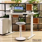 Modern height-adjustable white desk with laptop and ergonomic stool in a home office setting