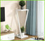 Modern indoor plant pot stand with two white shelves, holding potted plants in a bright living room corner.