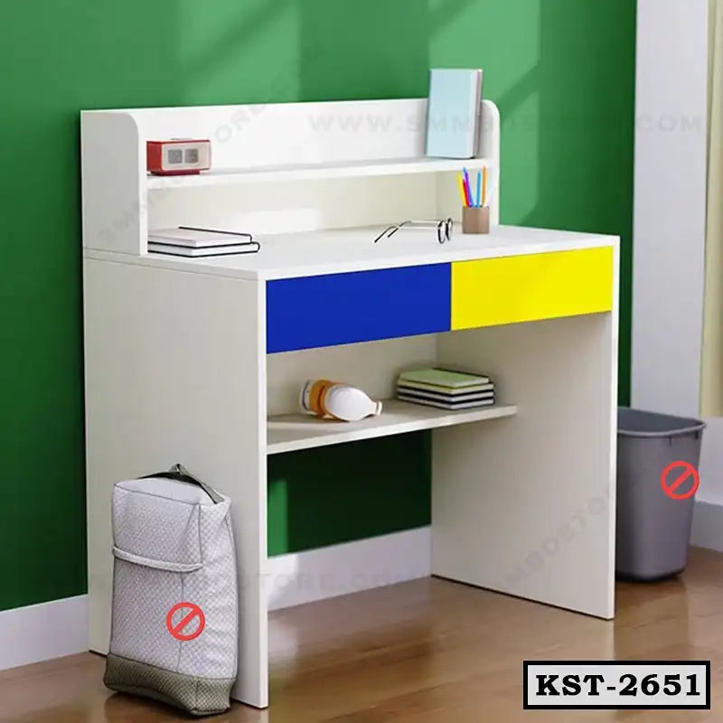 Kids study table with blue and yellow drawers, bookshelf, and storage shelf against green wall Main image