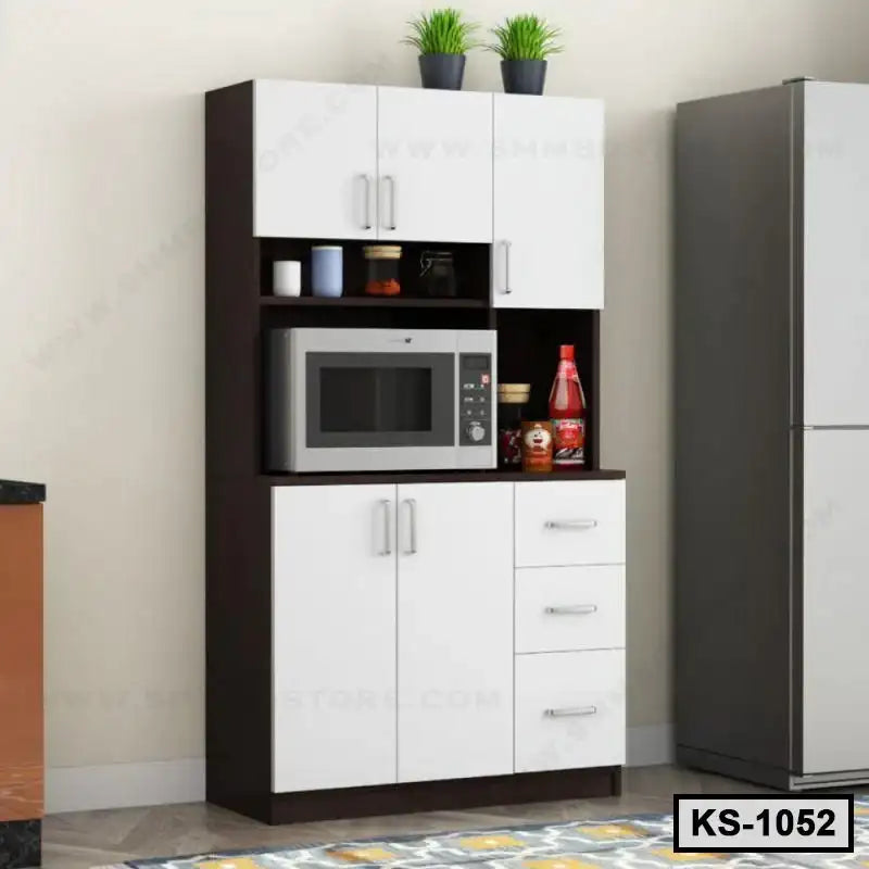 Modern kitchen shelf with white cabinets, microwave, potted plants, and storage drawers