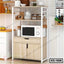 Modern kitchen shelf with microwave, storage cabinets, and utensils in a bright kitchen