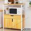 Modern wooden kitchen shelf with microwave, storage cabinets and utensils.