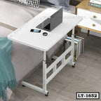 Adjustable white laptop table with wheels beside a bed, ideal for home office use