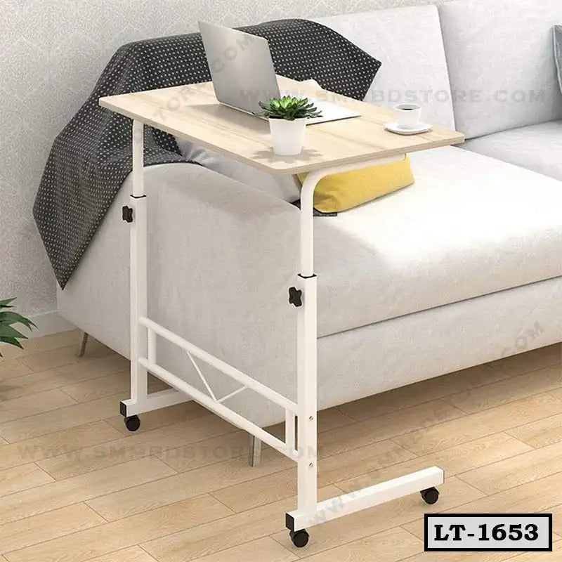 Adjustable rolling laptop table beside sofa in modern living room with laptop and coffee cup