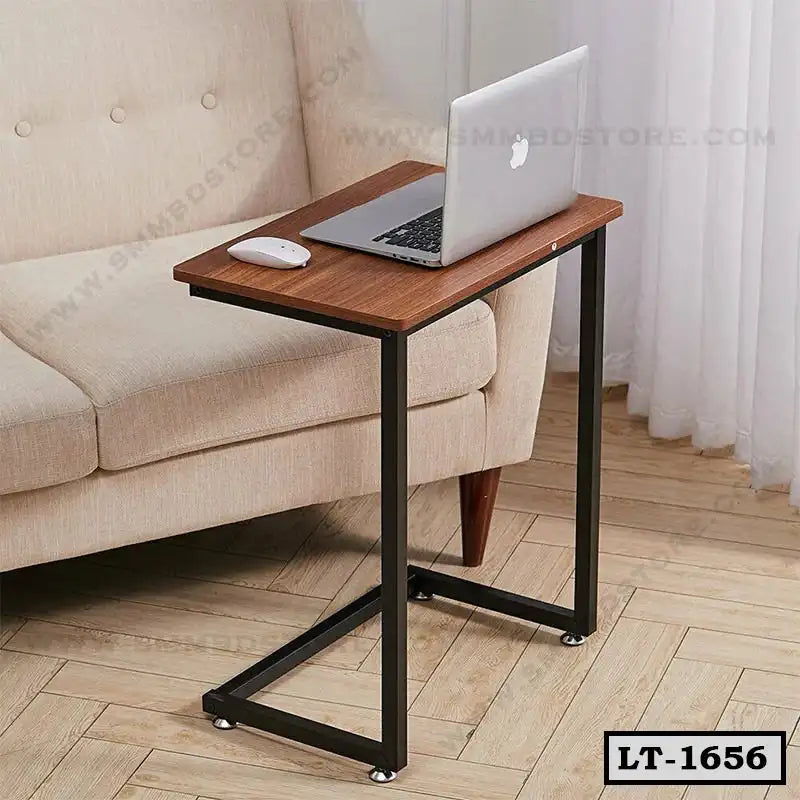 Wooden laptop table with metal frame beside beige sofa in living room