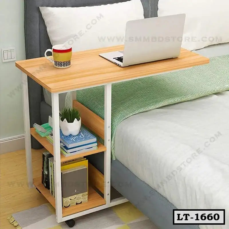 Adjustable laptop table with storage shelves beside bed, featuring books, plant, and coffee mug.