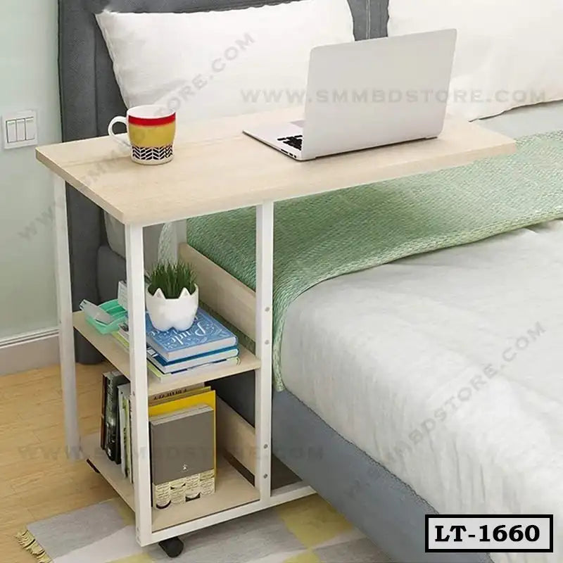Adjustable wooden laptop table with storage shelves beside a bed, ideal for home office use.