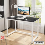 Modern home office desk with black tabletop, white frame, and computer in bright room