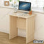Light wood laptop table for home office with computer, keyboard, and desk accessories