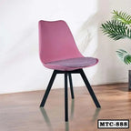 Modern pink metal tulip chair with black legs on wooden floor, indoor setting
