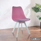 Modern metal tulip chair with pink seat and white legs on wooden floor, indoor setting