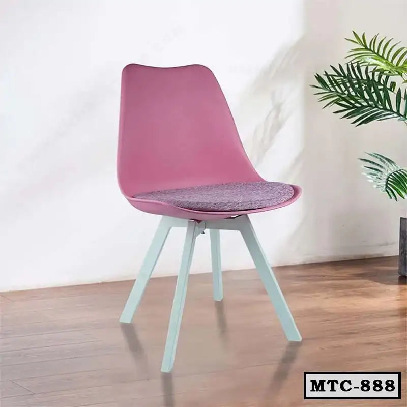 Modern metal tulip chair with pink seat and white legs on wooden floor, indoor setting