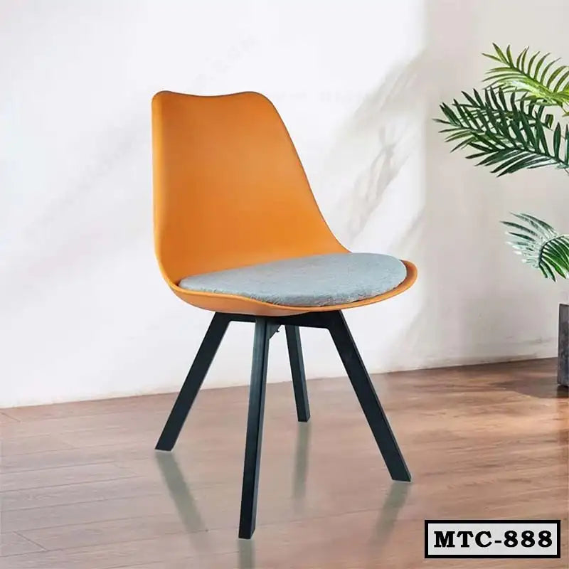 Modern orange metal tulip chair with grey cushion, black legs, on wooden floor indoors