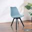 Modern metal tulip chair with blue seat and black legs on wooden floor, home interior