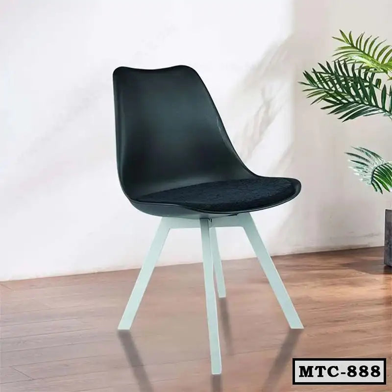 Modern black metal tulip chair with white legs on a wooden floor, indoor setting