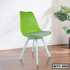 Modern green metal tulip chair with cushioned seat on wooden floor, next to indoor plant