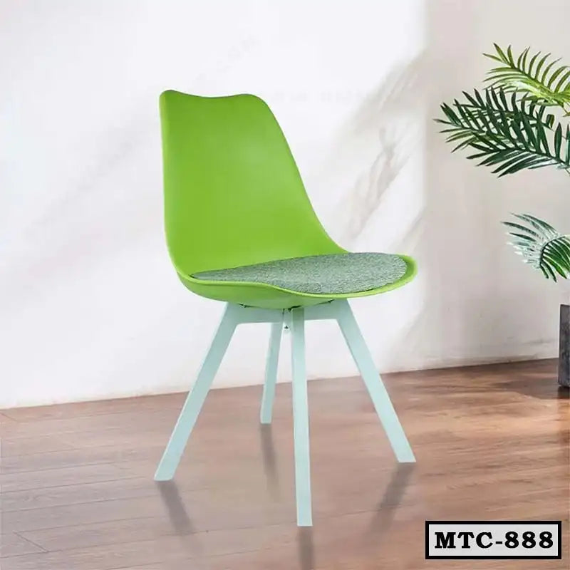 Modern green metal tulip chair with cushioned seat on wooden floor, next to indoor plant
