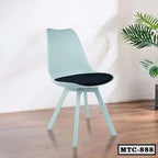 Modern metal tulip chair with black cushion on wood floor, minimalist home interior