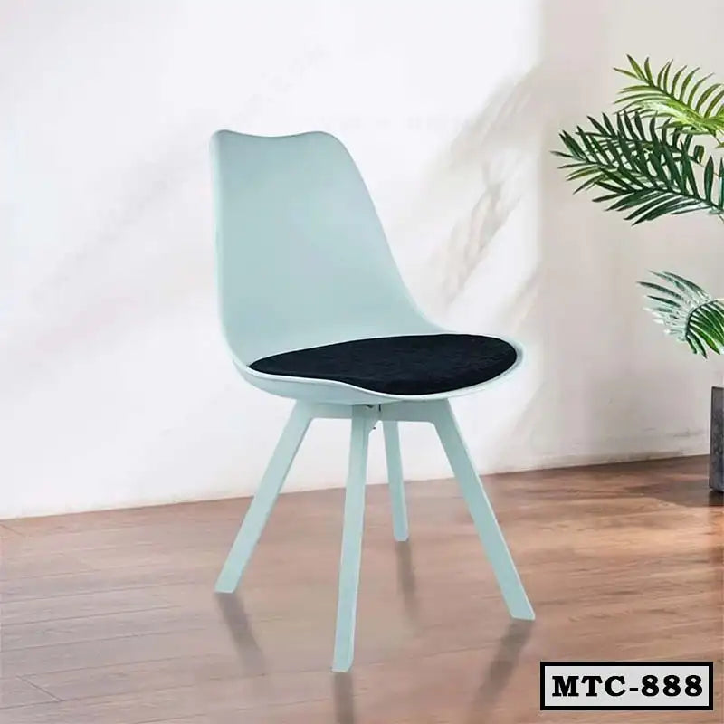 Modern metal tulip chair with black cushion on wood floor, minimalist home interior