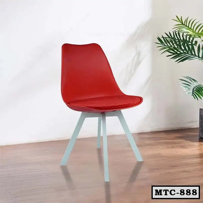 Modern red metal tulip chair with white legs on wooden floor, indoor home office setting