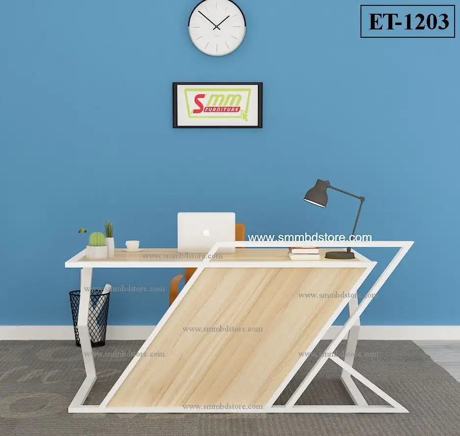Modern office desk with lamp, laptop, plants, and abstract frame against blue wall