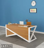 Modern wooden office desk with white metal frame, laptop, and accessories in a blue-walled workspace.