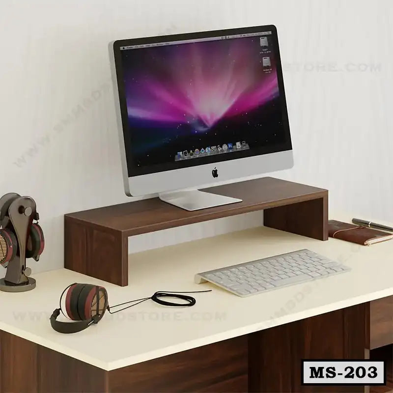 Wooden monitor stand on office desk with iMac, headphones, keyboard, and accessories.