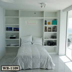 Modern white murphy wall bed with built-in shelves in a bright bedroom with sea view