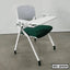 Modern office chair with white frame, green cushioned seat, and attached foldable writing desk