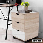 Modern office drawer unit with three wood drawers on wheels beside a desk