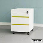 White office drawer unit with three drawers, yellow accents, lock, and wheels, against blue wall