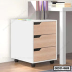 Modern office drawer unit with three wood-finish drawers on wheels beside a white desk