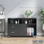 Modern black office file cabinet with drawers, shelves, and casters, holding documents and decor.