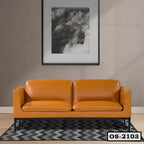 Modern orange leather office sofa with metal legs on patterned rug in a minimalist room