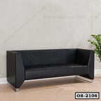 Modern black office sofa with angular armrests and metal legs in a minimalist room