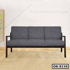 Modern three-seater office sofa with dark grey cushions and wooden frame, placed on wood floor