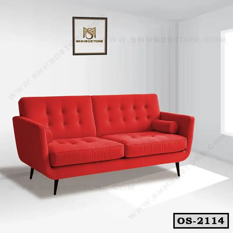 Modern red office sofa with button tufting and cylindrical cushions in a bright room