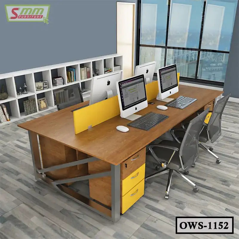 Modern office workstation with wood desk, yellow drawer units, and computers in open workspace