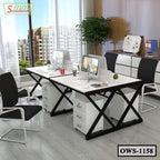 Modern office workstation desk with computers, black chairs, and storage drawers in a bright workspace