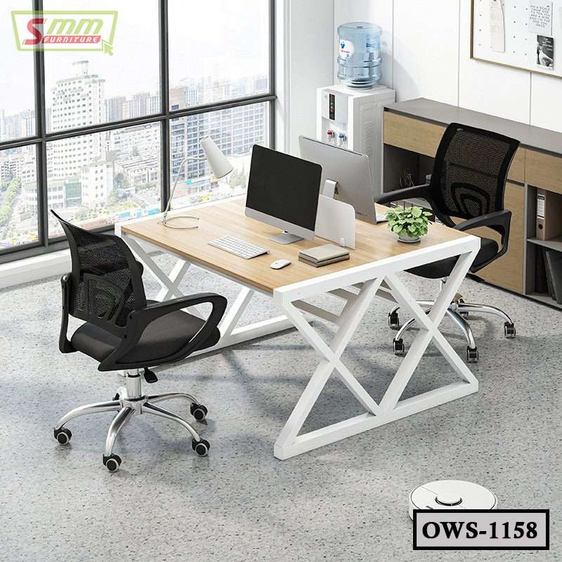 Modern office workstation with two ergonomic mesh chairs, wooden desk, and computers by large window