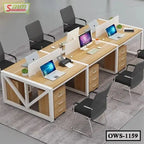Modern office workstation with four wooden desks, computers, partition panels, and black chairs