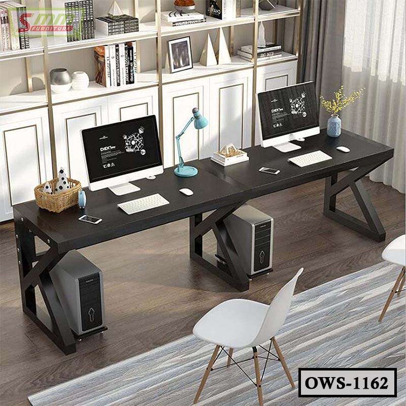 Modern office workstation table with dual computers, black desktop, shelves and chairs.