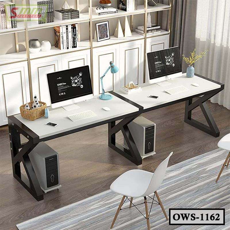 Modern office workstation with dual white desks, computers, black frames, and decorative shelves