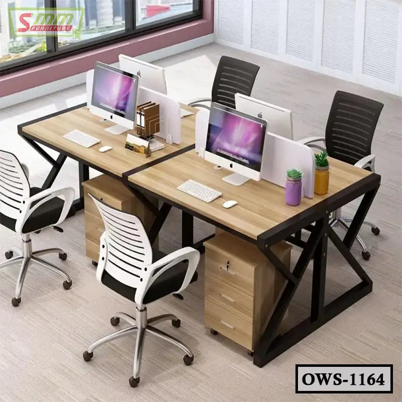 Modern office workstation for four with wood desks, black chairs, monitors, and storage drawers