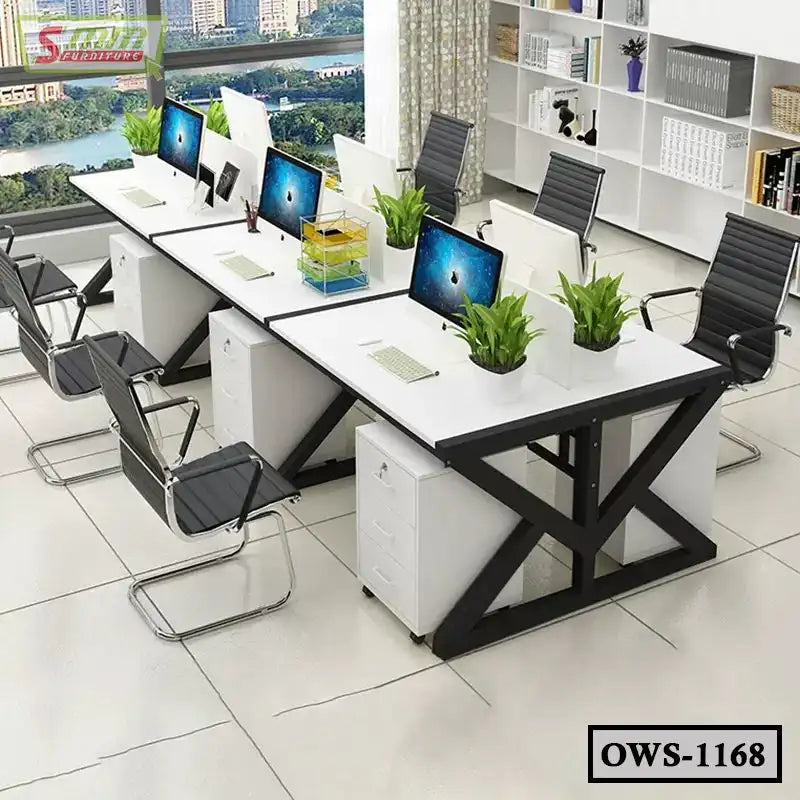 Modern office workstation with white desks, black chairs, computers, and indoor plants