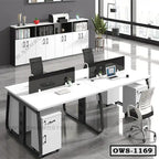 Modern office workstation desk with black chairs, storage cabinets, and laptops in a bright workspace