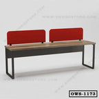 Modern office workstation desk with wood top, black metal frame, and red privacy panels