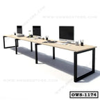 Modern office workstation desk with computers and accessories on a long wooden table