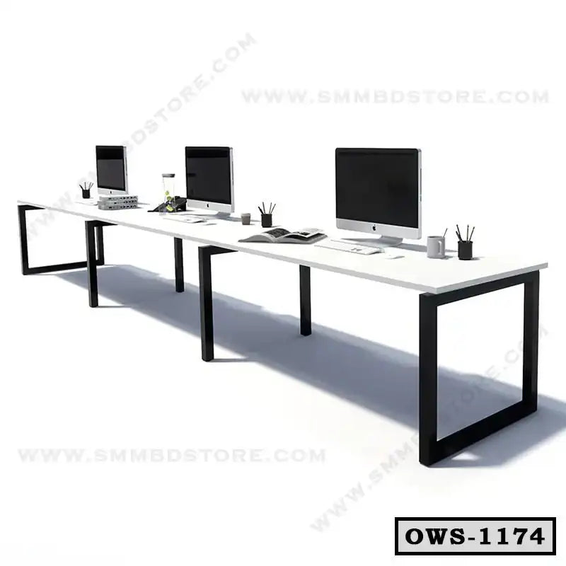 Modern office workstation desk with black metal frame, computers, and desk accessories