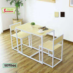 Modern rectangular dining table with two chairs, light wood top and white metal frame, indoor setting